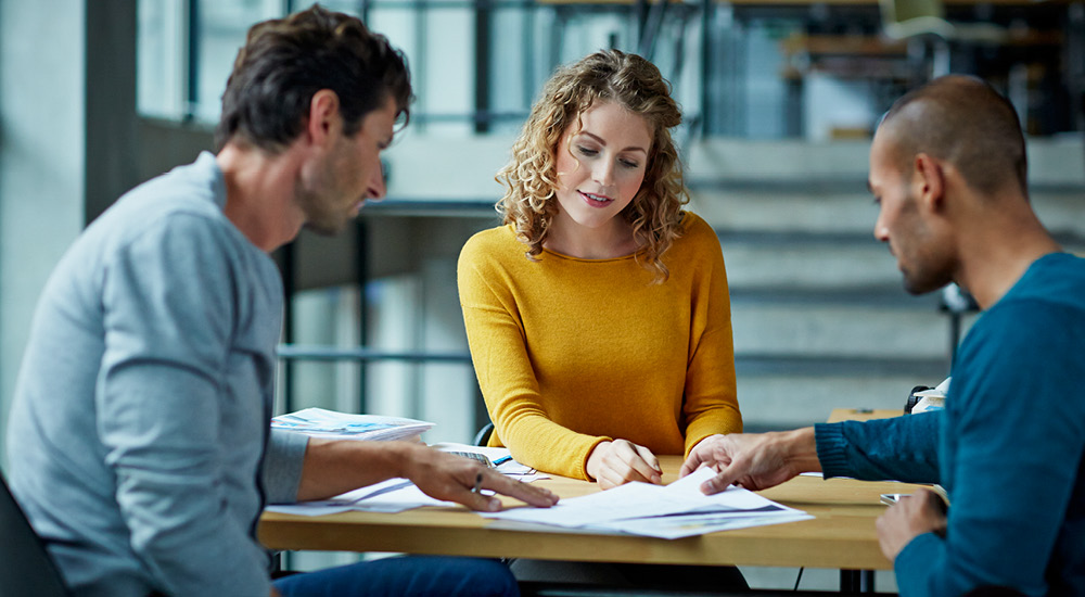 Two men and a woman working collaboratively in a work environment